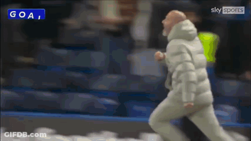 Man In White Jacket Running Past Goal Sign GIF