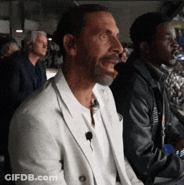Man In White Jacket With Microphone In Ear GIF