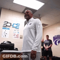 Man In White Nike Shirt In Front Of K Wall GIF