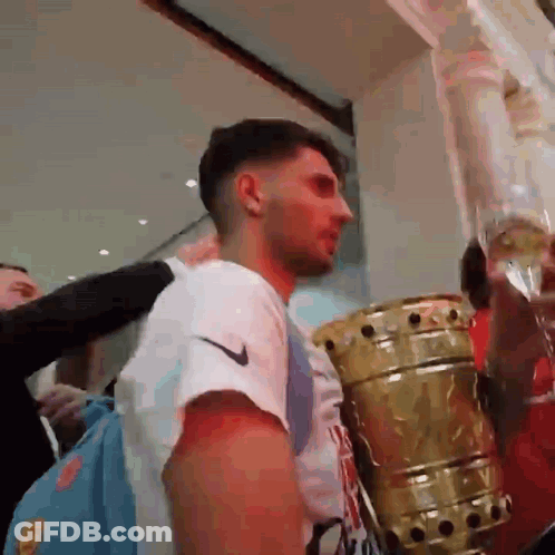 Man In White Nike Shirt Standing Next To Trophy GIF