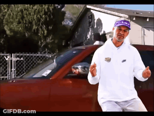 Man In White Nike Sweatshirt In Front Of Red Car GIF