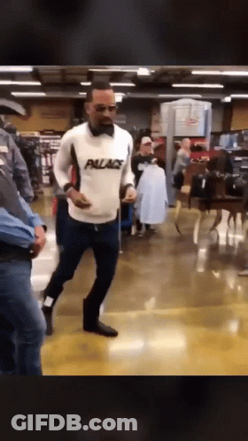 Man In White Palace Sweater Walking Through Store GIF