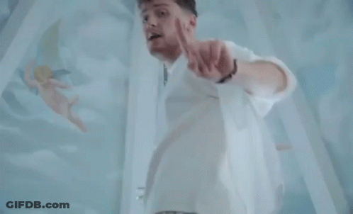 Man In White Pointing At Camera With Angels GIF