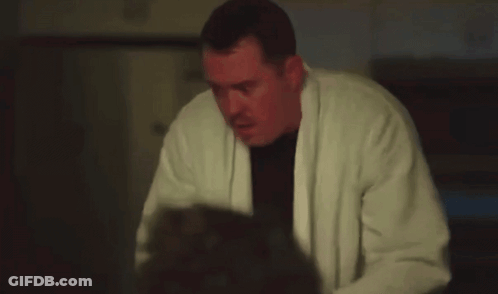 Man In White Robe Holding Gun In Dark Room GIF