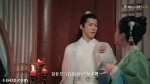 Man In White Robe Next To Woman In Green GIF