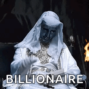 Man In White Robe Sitting In Front Of Fire With Billionaire Text GIF