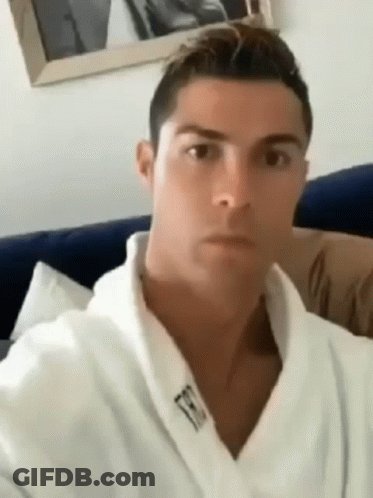 Man In White Robe Sitting On Couch Looking At Camera GIF