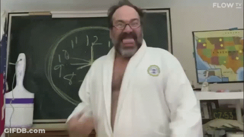 Man In White Robe Standing Before Blackboard GIF