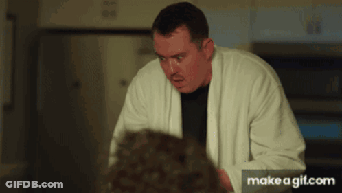 Man In White Robe Standing In Front Of Microwave GIF