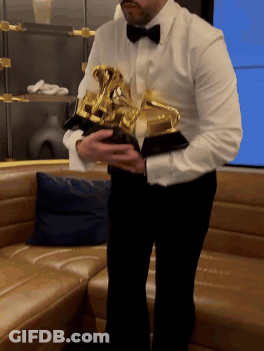 Man In White Shirt And Black Bow Tie Holding Trophy GIF