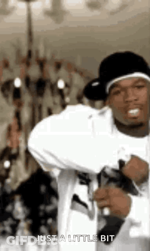 Man In White Shirt And Black Hat Holding Microphone Saying Just A Little Bit GIF
