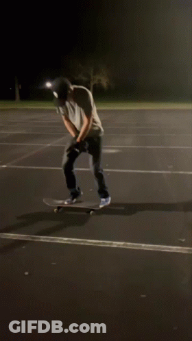 Man In White Shirt And Black Hat On Skateboard At Night GIF