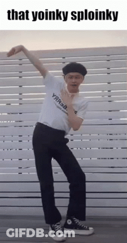 Man In White Shirt And Black Pants Dancing In Front Of Fence Saying That Yoinky Sploinky GIF