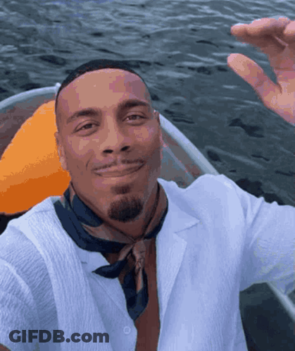 Man In White Shirt And Black Scarf Smiling In Boat GIF