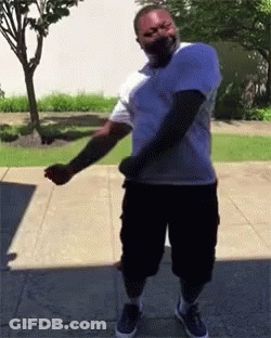 Man In White Shirt And Black Shorts Dancing On Sidewalk GIF