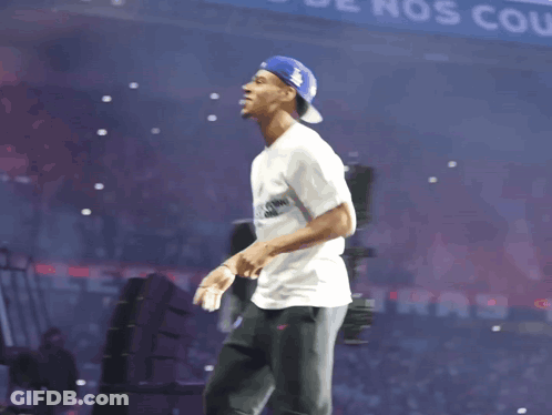 Man In White Shirt And Blue Hat Before Banner Saying Nos Coule GIF
