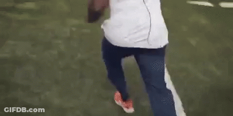 Man In White Shirt And Blue Pants Walking On Football Field GIF
