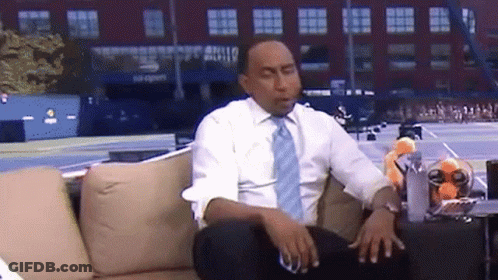 Man In White Shirt And Blue Tie On Couch In Front Of US Open Sign GIF