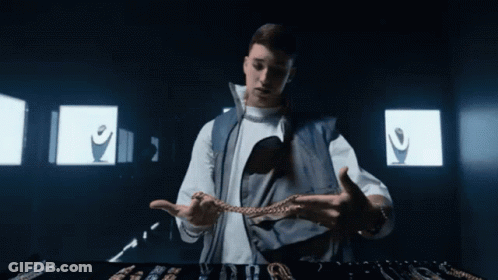 Man In White Shirt And Blue Vest Holding Chain GIF