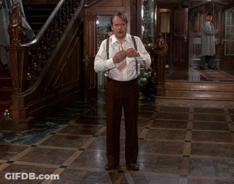 Man In White Shirt And Brown Pants Standing In Room GIF