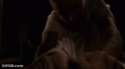 Man In White Shirt And Glasses On Table In Dark GIF