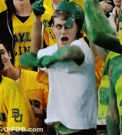 Man In White Shirt And Green Gloves Standing Before Crowd GIF
