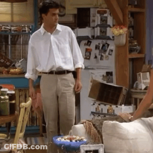 Man In White Shirt And Khaki Pants By Refrigerator GIF