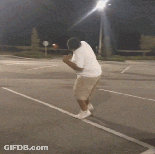 Man In White Shirt And Khaki Shorts Running On Parking Lot GIF