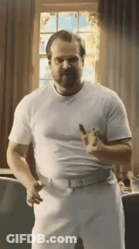 Man In White Shirt And Pants Standing By Window GIF