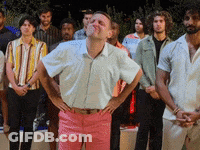 Man In White Shirt And Pink Pants Standing Before Group GIF