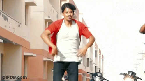 Man In White Shirt And Red Jacket Standing In Front Of Building GIF