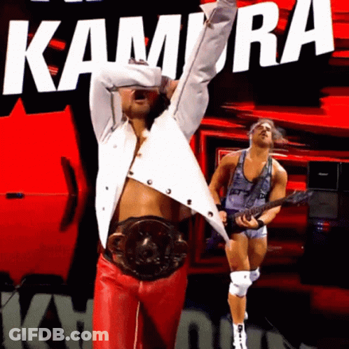 Man In White Shirt And Red Pants In Front Of Kamira Sign GIF