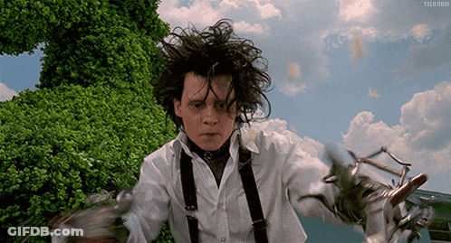 Man In White Shirt And Suspenders Holding Scissors GIF