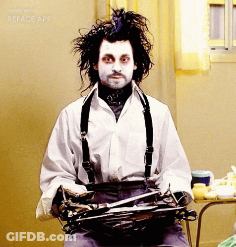 Man In White Shirt And Suspenders Holding Scissors GIF