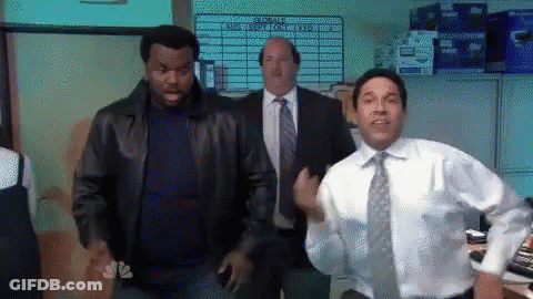 Man In White Shirt And Tie Dancing In Front Of NBC Sign GIF