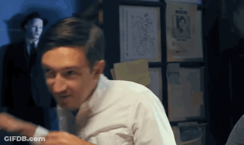 Man In White Shirt And Tie In Front Of Wall With Papers 15 GIF