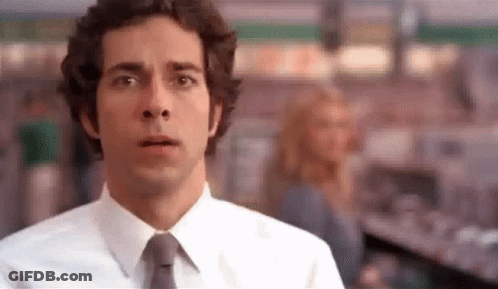 Man In White Shirt And Tie Looking At Camera In Store GIF