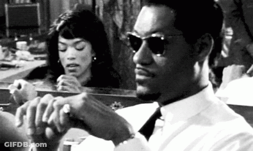 Man In White Shirt And Tie Sitting In Front Of Mirror While Woman Looks At Him GIF