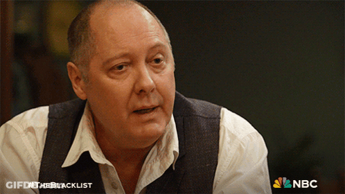 Man In White Shirt And Vest In Front Of NBC Logo GIF