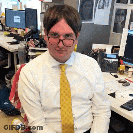 Man In White Shirt And Yellow Tie Sitting At Desk GIF
