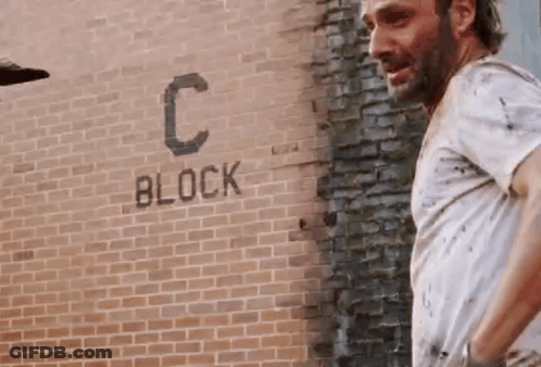 Man In White Shirt At Brick Wall With Block GIF
