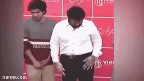 Man In White Shirt Before Red Wall Saying Manaso GIF