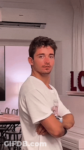 Man In White Shirt Crosses Arms In Front Of Love Sign GIF