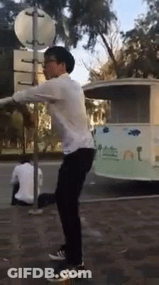 Man In White Shirt Doing Trick On Street GIF