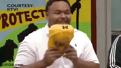 Man In White Shirt Eating Yellow Object With Letter W GIF