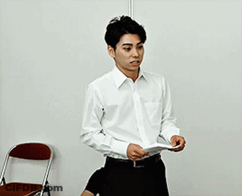 Man In White Shirt Holding Paper Near Chair GIF