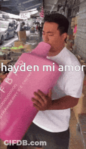 Man In White Shirt Holding Pink Container Saying Hayden Mi Amor GIF