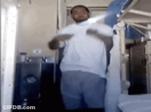 Man In White Shirt Holding Shirt Up In Bathroom GIF