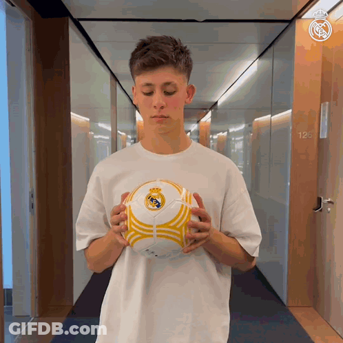 Man In White Shirt Holding Soccer Ball Hallway GIF