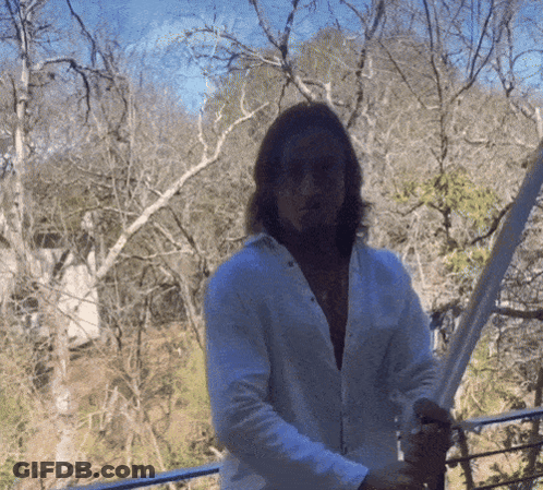 Man In White Shirt Holding Sword In Forest GIF